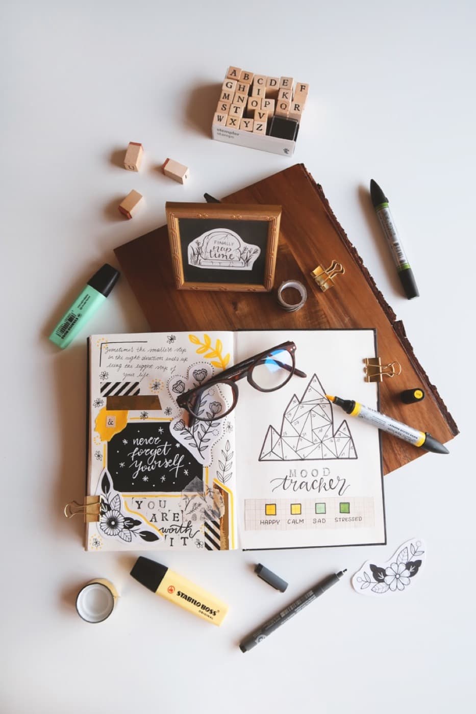 Planner, glasses, and pens on a desk